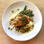 Chicken piccata served with mashed potatoes, green beans, and lemon caper sauce.