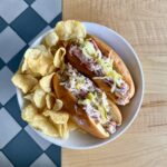 Lobster rolls with chilled lobster salad, dill mayo, and shredded pickles served on a toasted split-top bun.