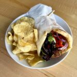 Vegetarian falafel naan sandwich with hummus, roasted red pepper, mixed greens, red onion and herb oil at Olives Restaurant in East Grand Rapids
