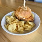 Nashville hot chicken sandwich with fried chicken breast, Nashville hot rub, ranch and housemade pickles on a brioche bun at Olives Restaurant in East Grand Rapids