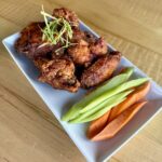 Twice-fried General Tso’s chicken wings tossed in General Tso’s sauce and topped with scallions at Olives Restaurant in East Grand Rapids
